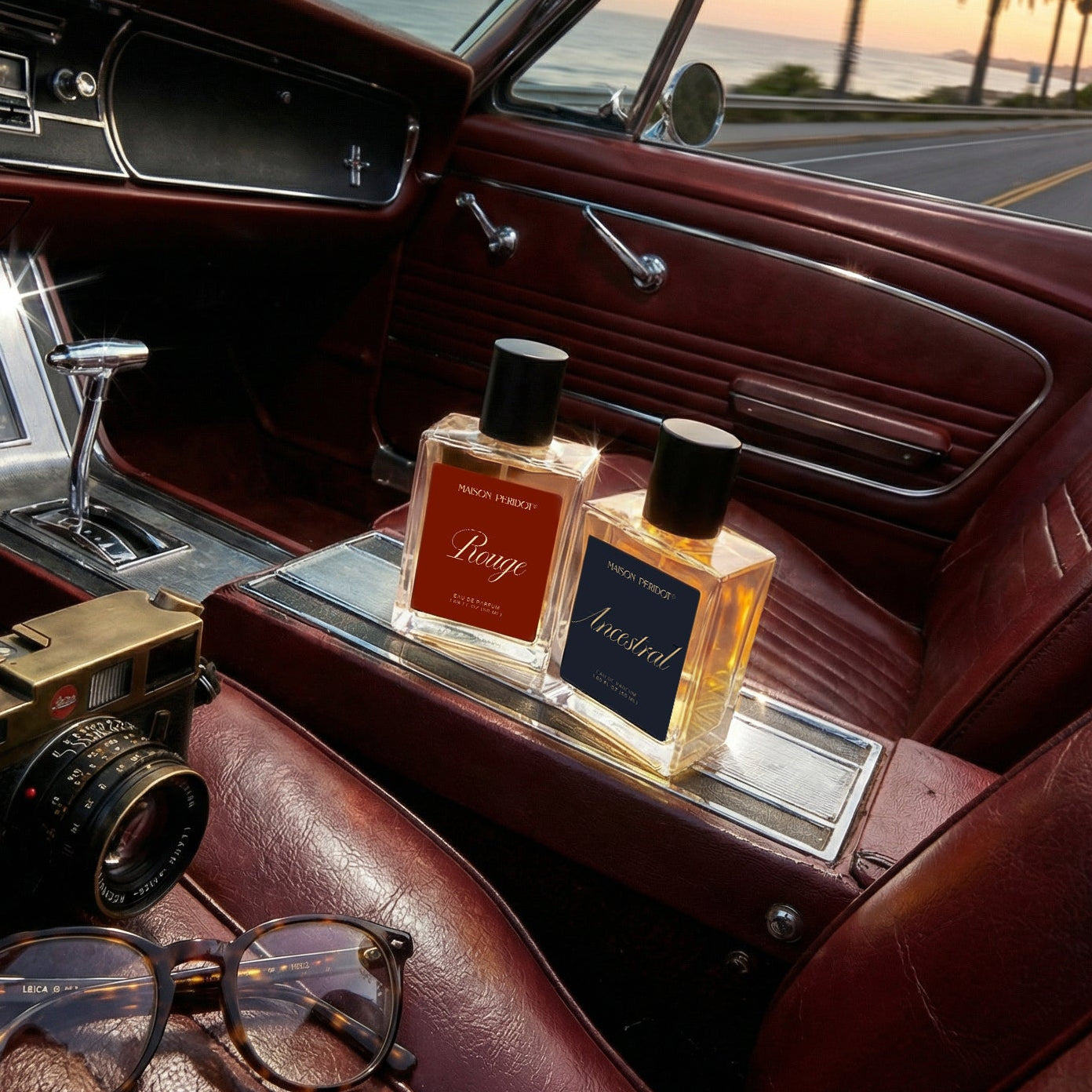 Vintage car interior with sunglasses, camera, and two bottles of perfume.